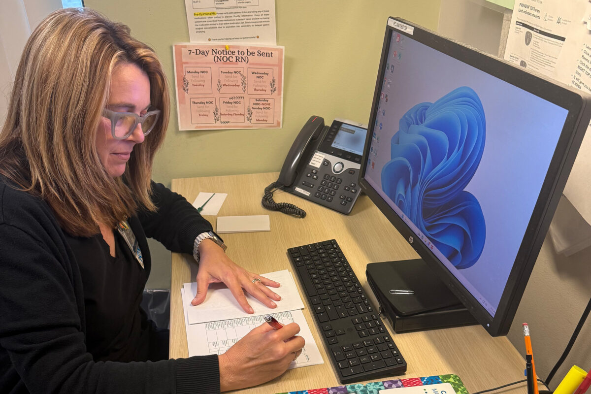 A PACU nurse reviews information before calling a patient.
