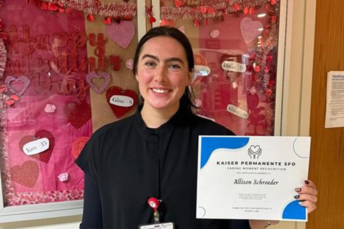 A nurse holding an award certificate