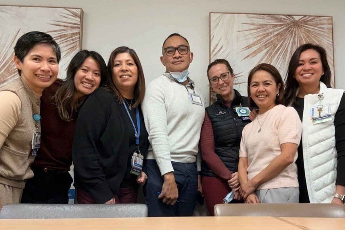 A group of nursing smiling in a conference room.