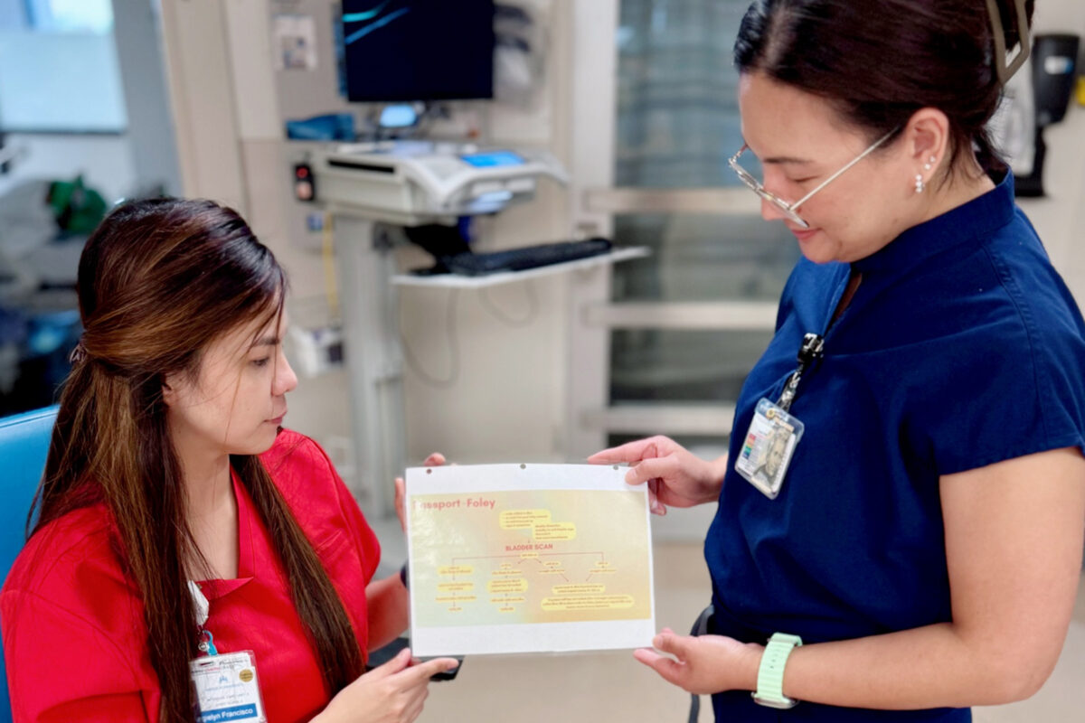 ICU nurses Sandiko and Francisco reviewing the algorithm together.