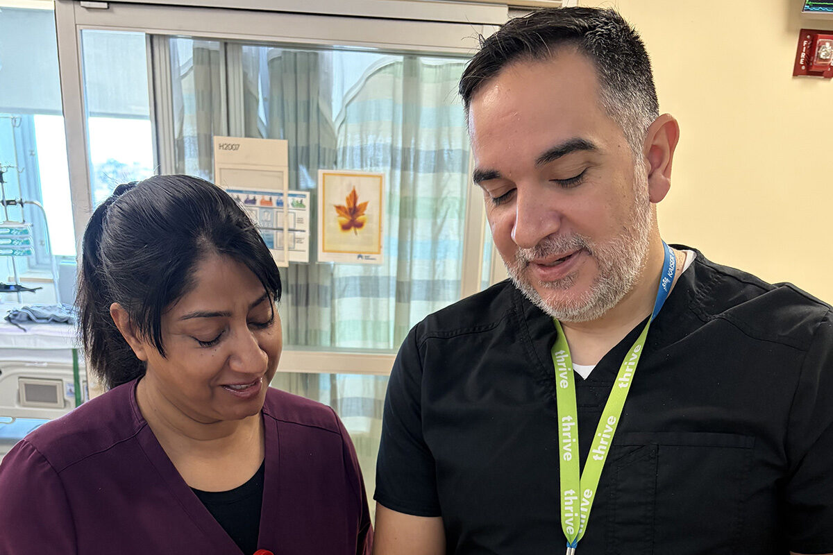 Two nurses looking down at a paper