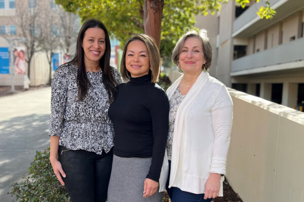 Nurses outside smiling by a tree