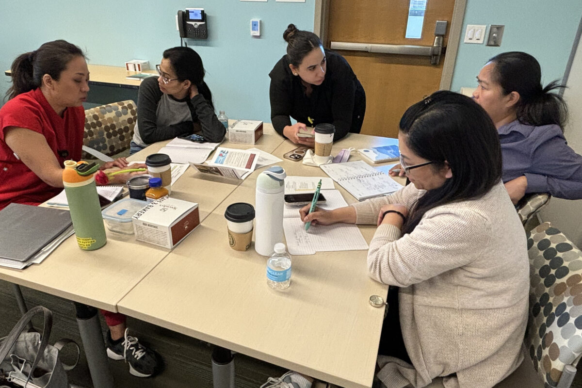 5 nurses gathered around a table