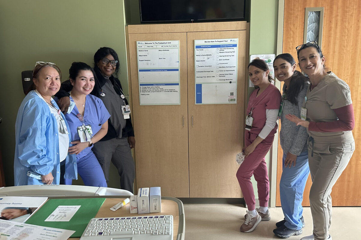 6 nurses around a care board in a patient room