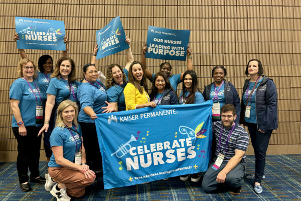 A group of nurses holding a banner and signs
