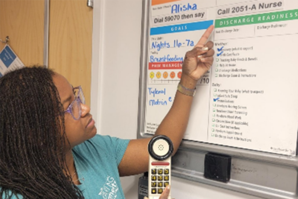 Alisha Thompson pointing to care board