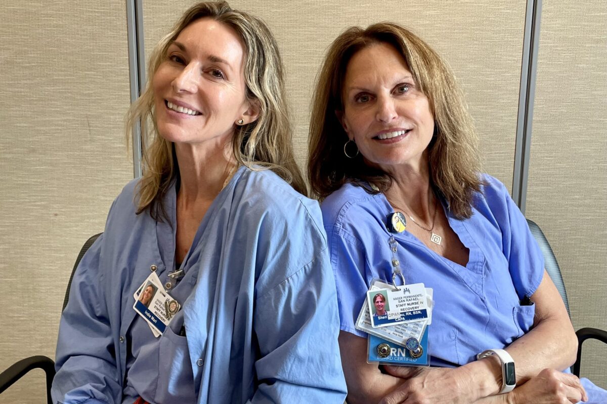 2 nurses sitting down smiling