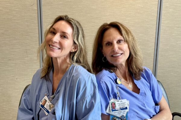 2 nurses sitting down smiling