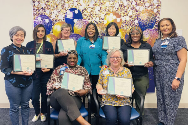 Nurses smiling with certificates.