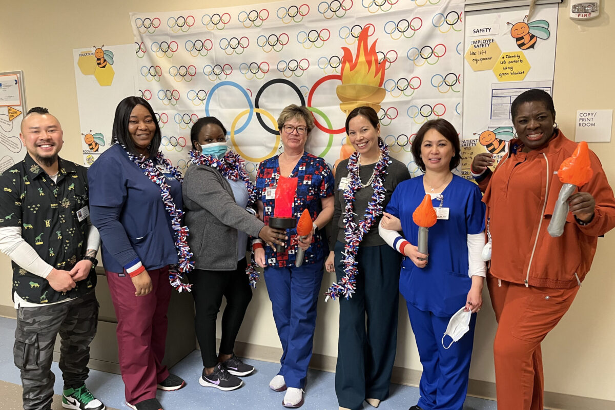 Nurses smiling with Olympic themed background