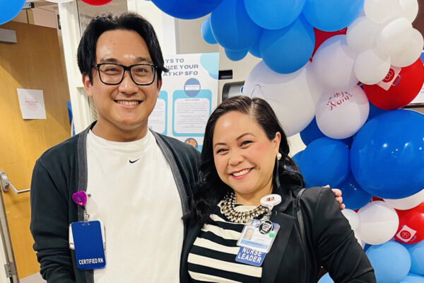 Two nurses smiling with balloons in the background