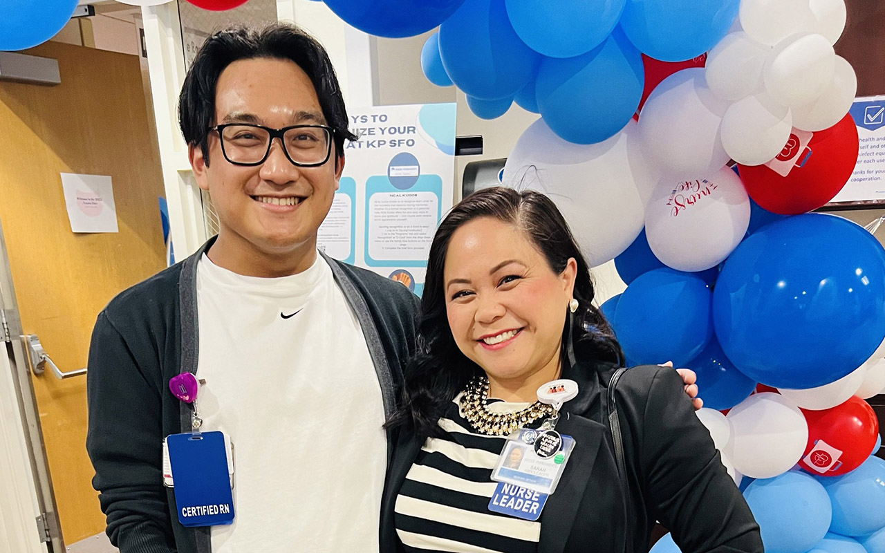 Two nurses smiling with balloons in the background