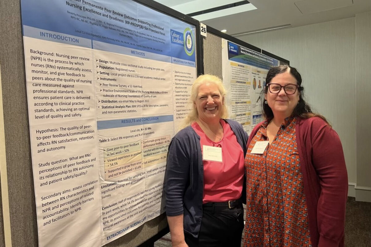 2 nurses in front of a poster presentation