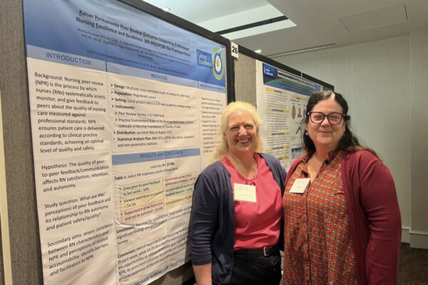 2 nurses in front of a poster presentation