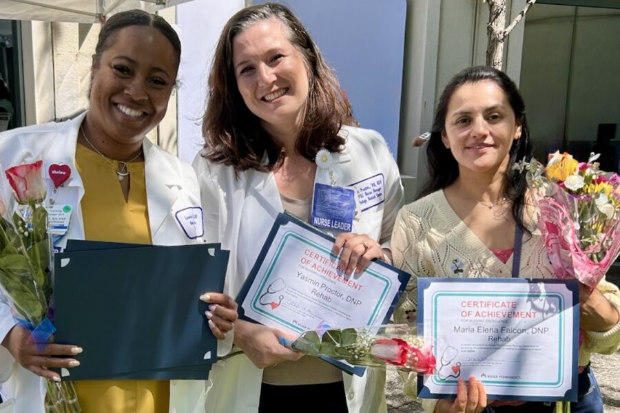3 nurses smiling with awards and flowers