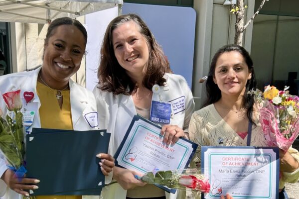 3 nurses smiling with awards and flowers