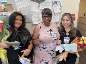 3 nurses smiling with flowers
