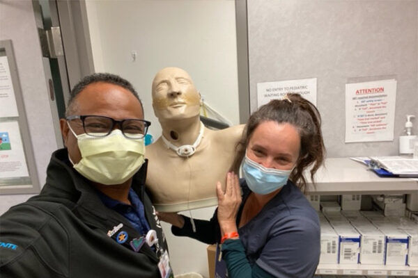 Respiratory therapist James Shepherd and assistant nurse manager Rebeca Haynes with Todd, a mannequin often used to help train nurses, patients, and families.