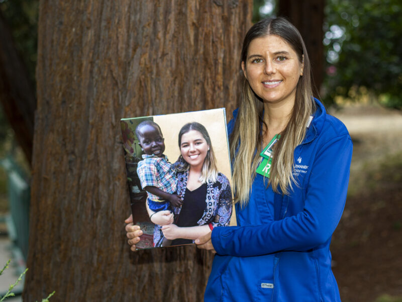 Kayla Billington, RN, With A Photo Of Her And Patrick, The Little Boy Who Died Of A Correctible Heart Defect And Who Inspired Her To Help Other Children In Uganda.