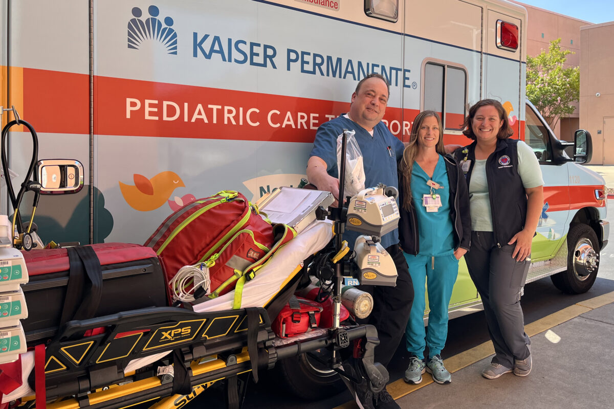 3 Nurses in front of an ambulance.