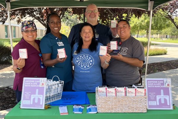 5 nurses holding medication.