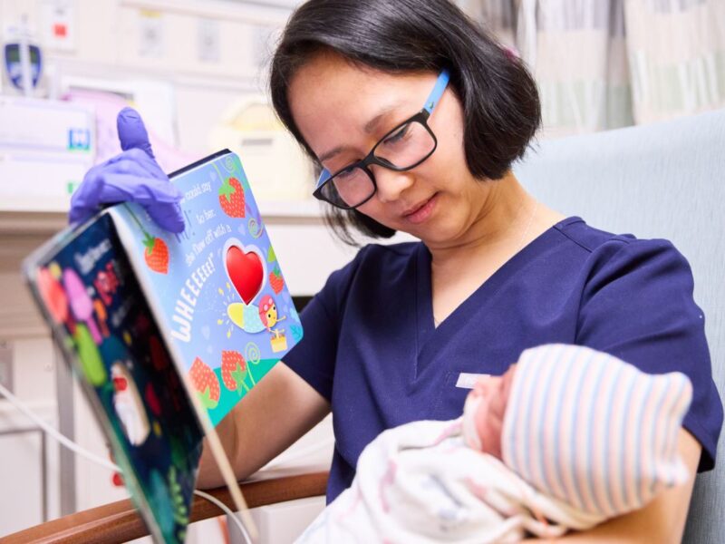 Nurse Reading To A Baby