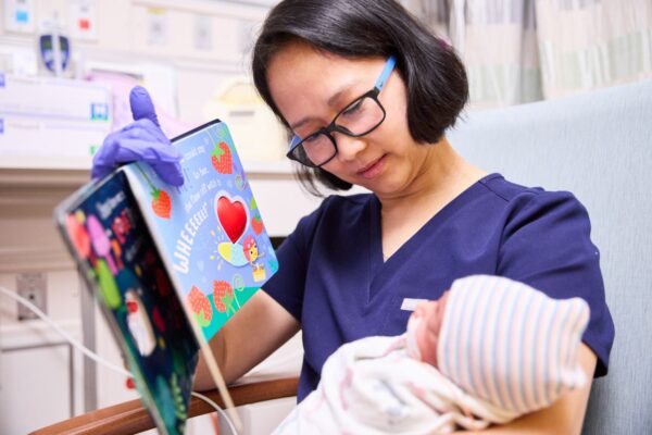 Nurse reading to a baby
