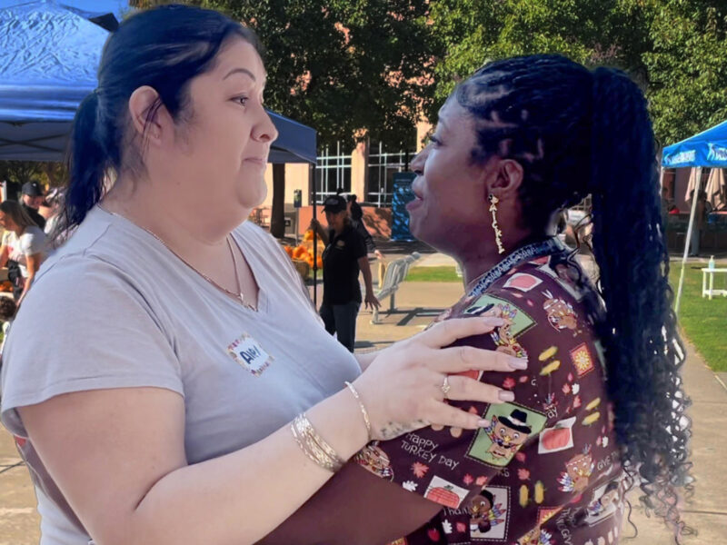 A Nurse And The Parent Of A NICU Baby Share A Hug.