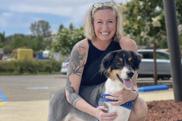 A nurse smiling with a dog.