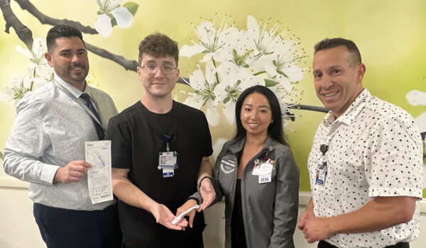 4 Nurses Smiling While Holding A Pulse Oximeter