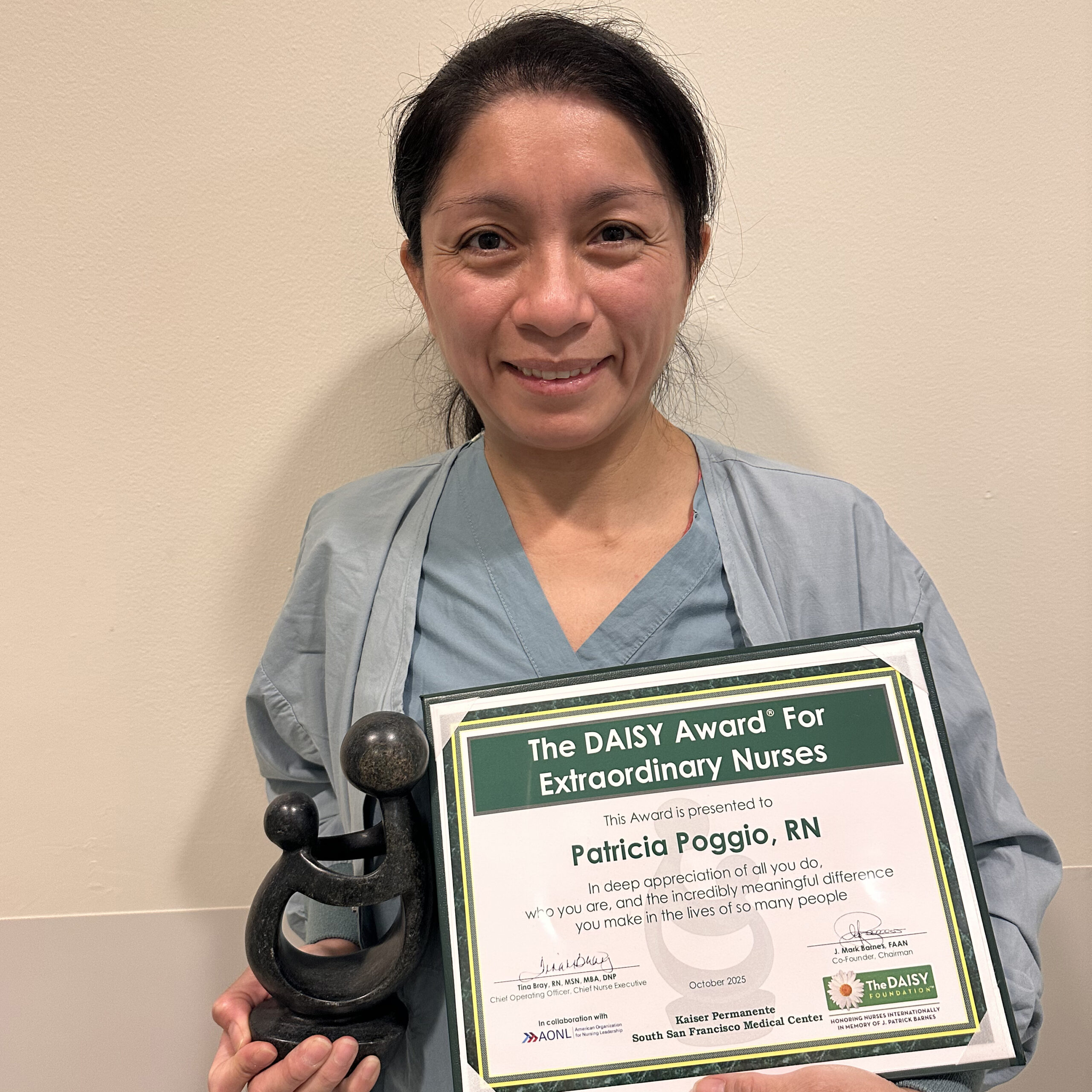Patricia Poggio holding a DAISY Award