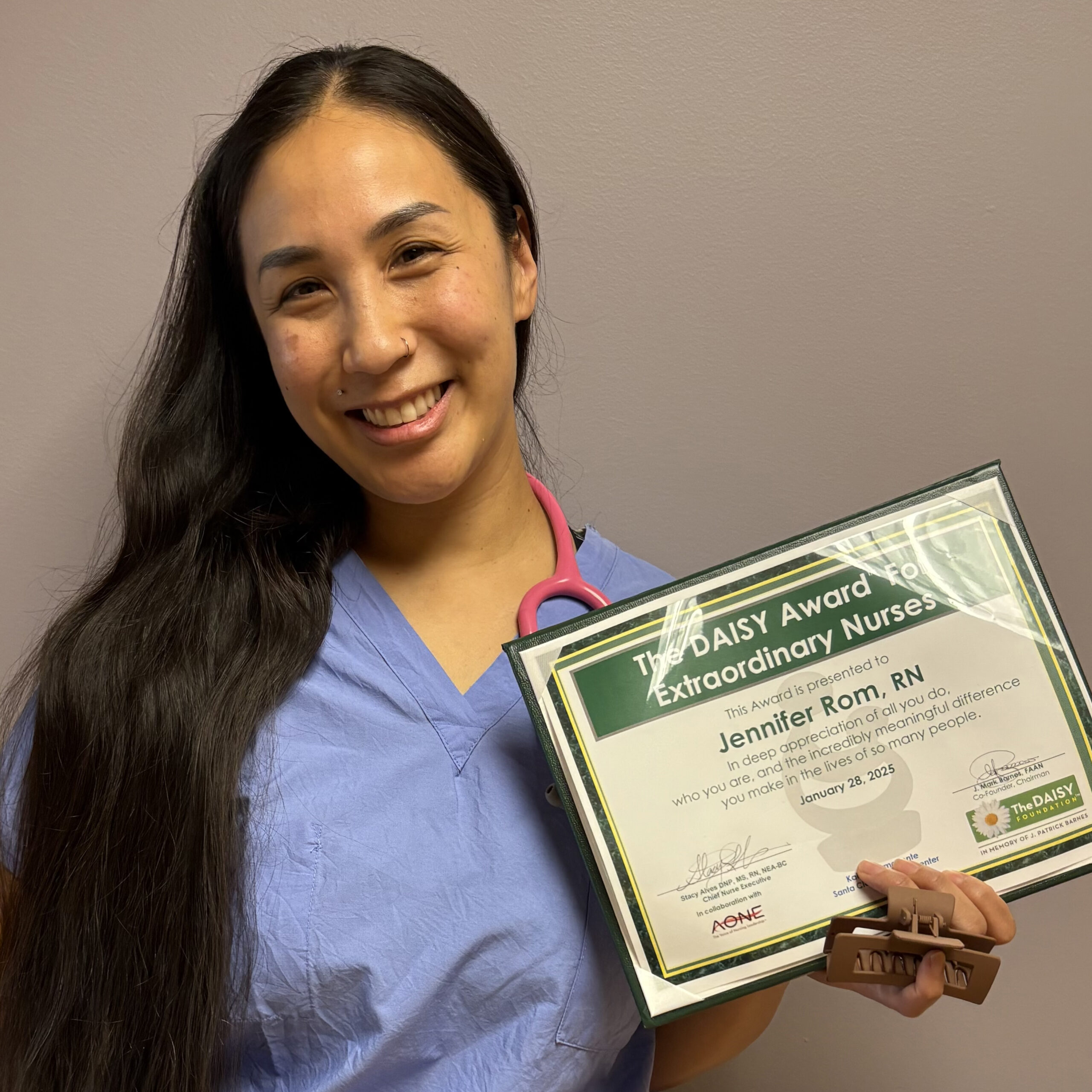 Jennifer Rom holding a DAISY Award