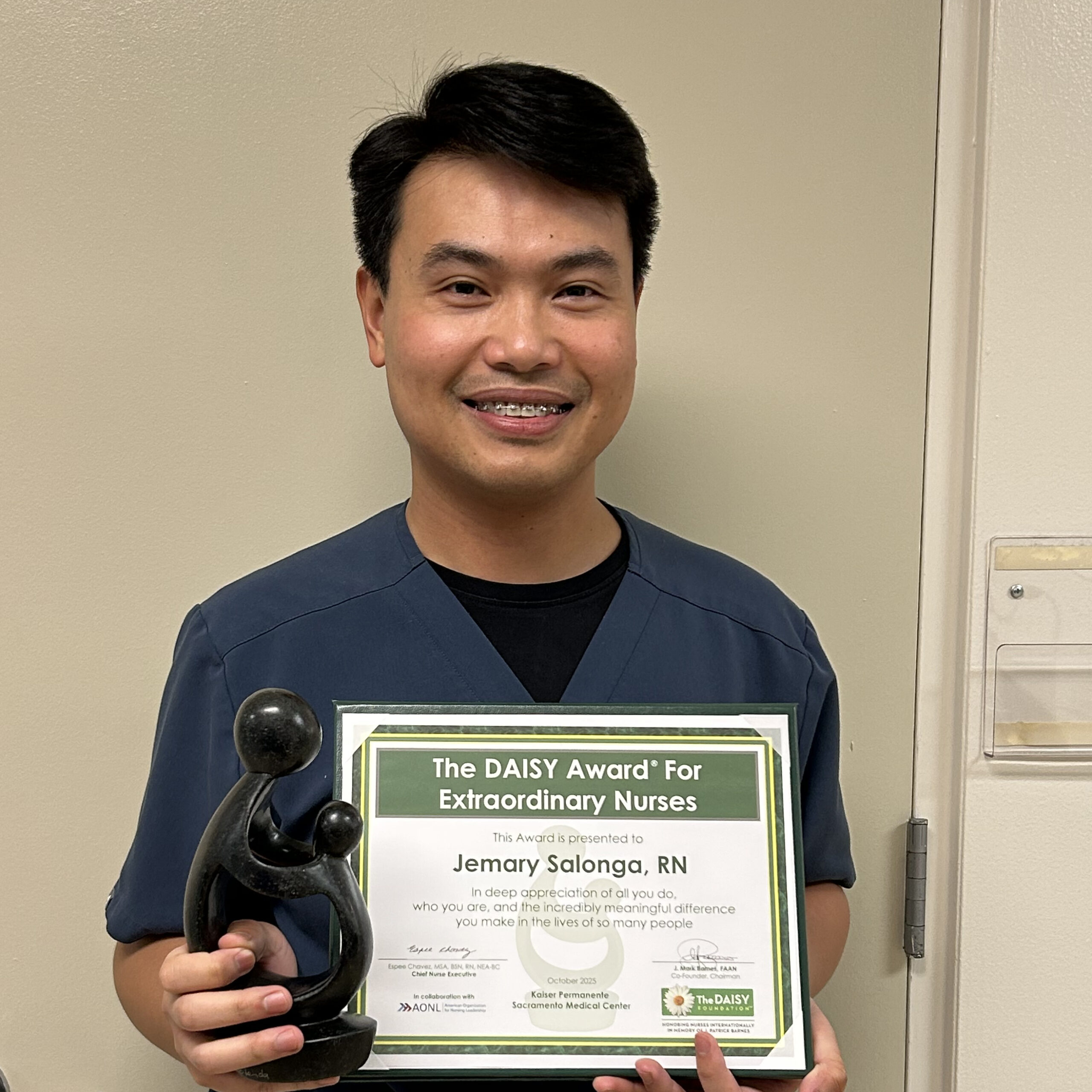 Jemary Salonga holding a DAISY award