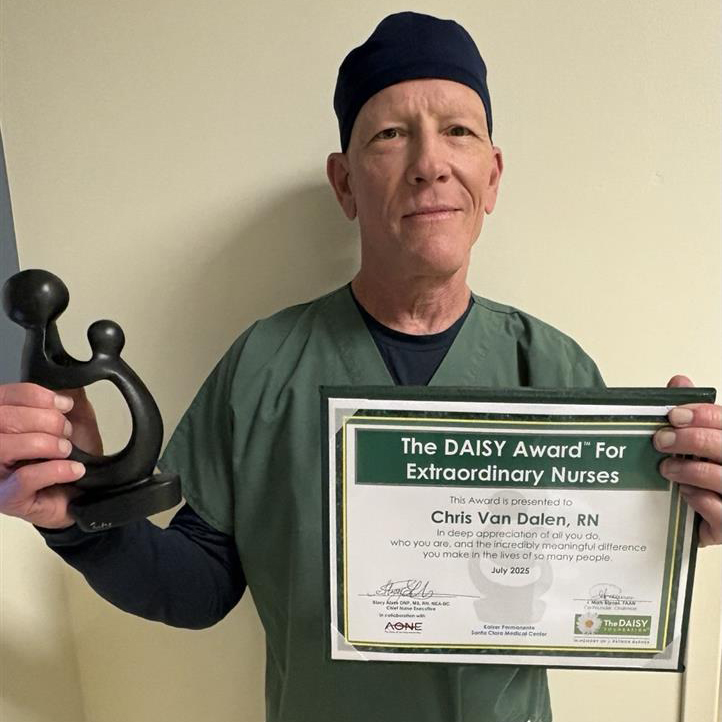 Chris Van Dalen holding a DAISY Award