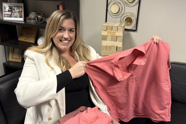 Nurse Katie Rolan holds up a pair of scrubs donated by colleagues.