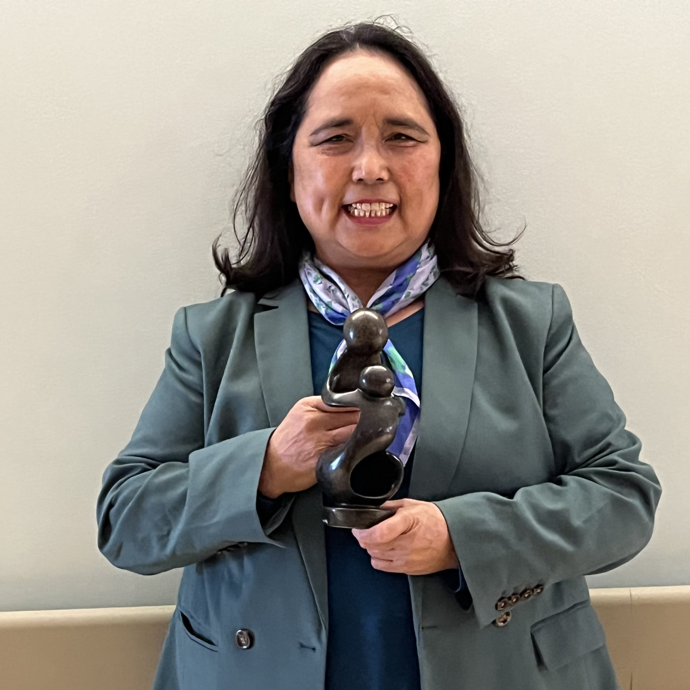 Mina Mai holding the statue of the DAISY Award