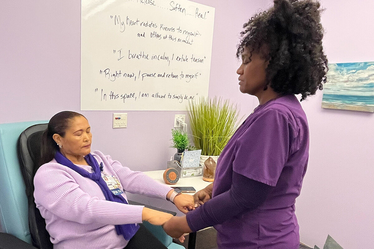 Gwendolyn Ekeh, RN guides colleague Tigist Ajibe, BSN, RN, through a meditation before her shift at the Oakland Medical Center.