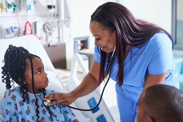 A nurse listening with a stethoscope on a pediatric patient.