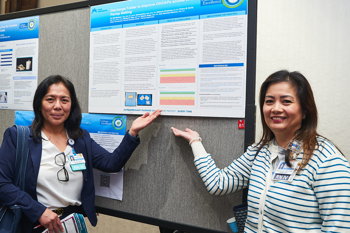 Fremont perioperative nurse Cherry David, at left, and intensive care nurse Melanie Tsao stand by the poster highlighting a project that improves post-surgery communication for patients.