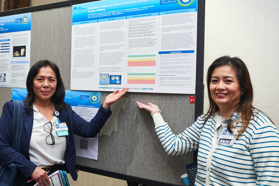 Fremont perioperative nurse Cherry David, at left, and intensive care nurse Melanie Tsao stand by the poster highlighting a project that improves post-surgery communication for patients.